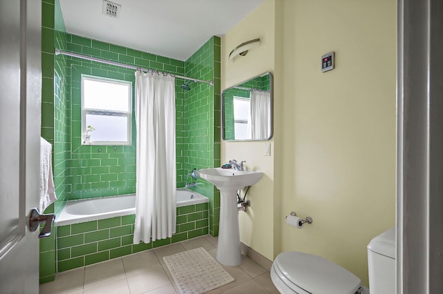 full bathroom with tiled shower / bath combo, toilet, tile patterned floors, and visible vents
