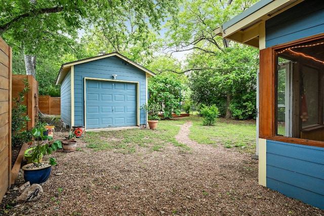 view of yard featuring a garage, fence, and an outdoor structure