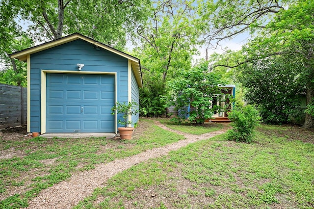 detached garage featuring fence
