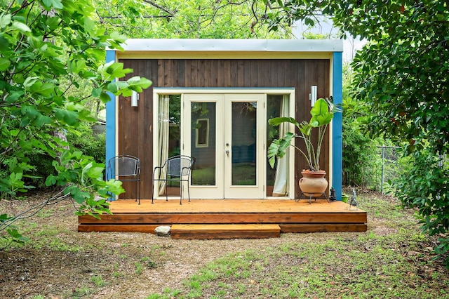 view of outbuilding featuring french doors, fence, and an outbuilding
