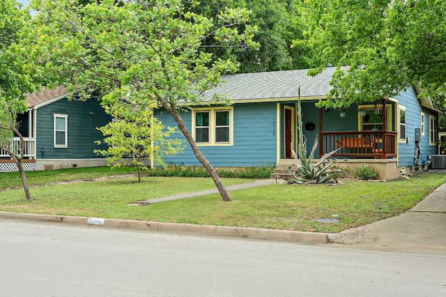 ranch-style home featuring a porch, roof with shingles, central AC, and a front yard