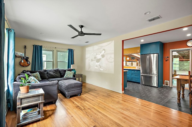 living room with ceiling fan, visible vents, wood finished floors, baseboards, and recessed lighting