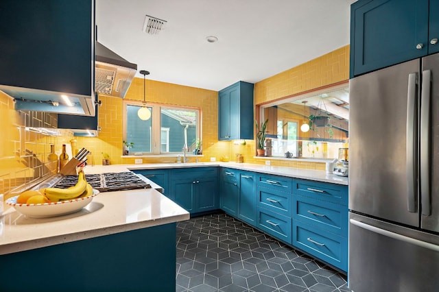 1516 Madison Ave, Austin, TX 78757 - kitchen featuring appliances with stainless steel finishes, blue cabinets, light countertops, decorative backsplash, and a sink