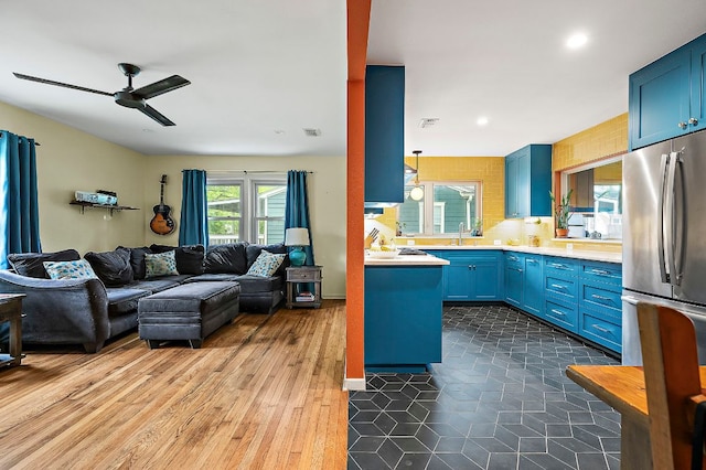1516 Madison Ave, Austin, TX 78757 - kitchen featuring open floor plan, freestanding refrigerator, blue cabinetry, a ceiling fan, and light countertops