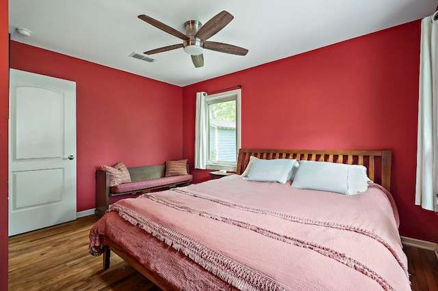bedroom with visible vents, baseboards, ceiling fan, and wood finished floors