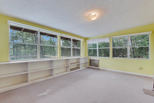 unfurnished sunroom with heating unit and plenty of natural light