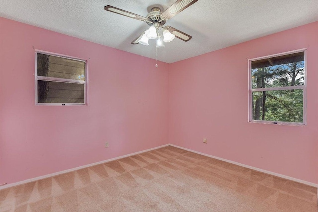 spare room with light colored carpet, baseboards, and ceiling fan