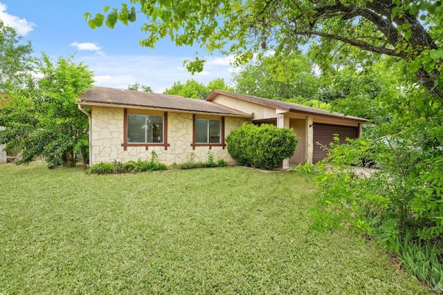 view of front of property featuring a garage, a front yard, and stone siding