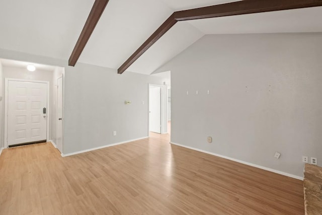 unfurnished living room featuring baseboards, vaulted ceiling with beams, and light wood-style floors