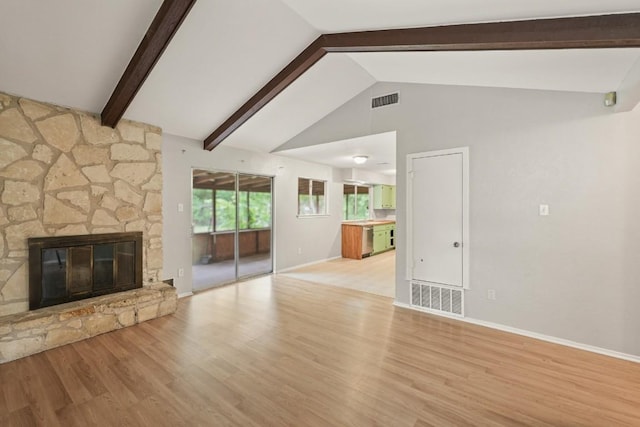 unfurnished living room featuring visible vents, wood finished floors, and vaulted ceiling with beams