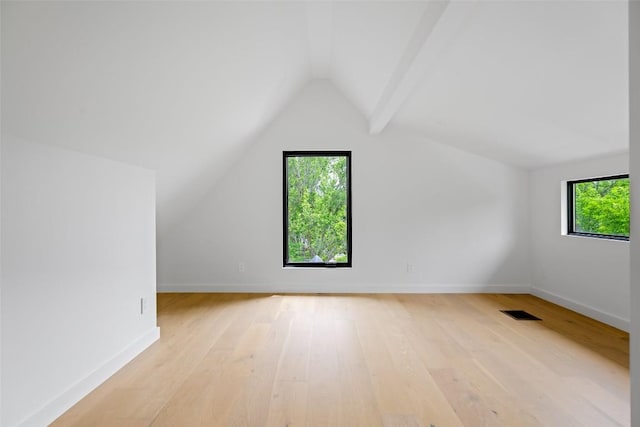 additional living space featuring baseboards, visible vents, light wood-type flooring, and lofted ceiling
