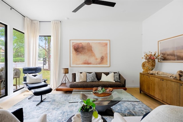 living area with a ceiling fan and light wood finished floors