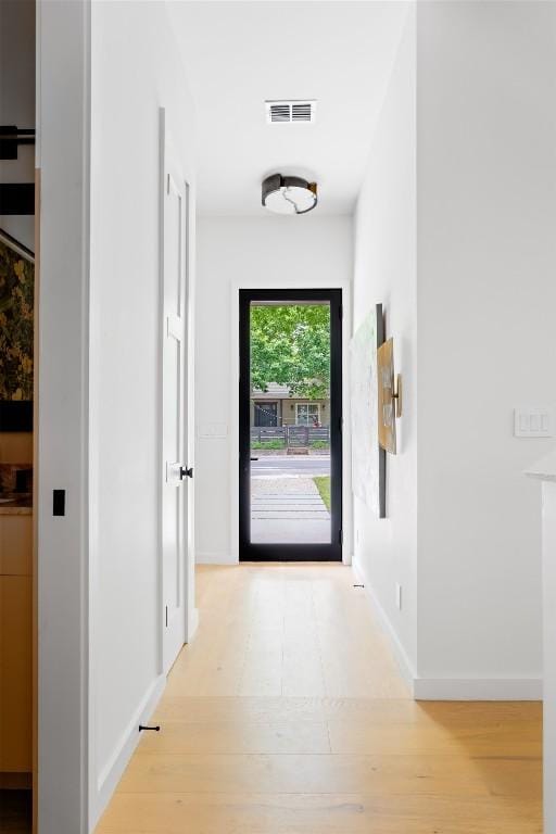 interior space featuring baseboards, wood finished floors, and visible vents