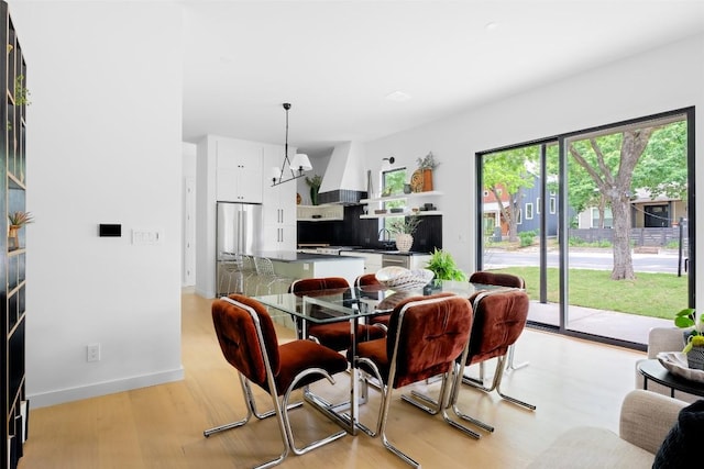 dining room featuring baseboards and light wood finished floors