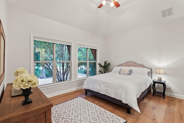 bedroom featuring visible vents, wood finished floors, baseboards, ceiling fan, and high vaulted ceiling