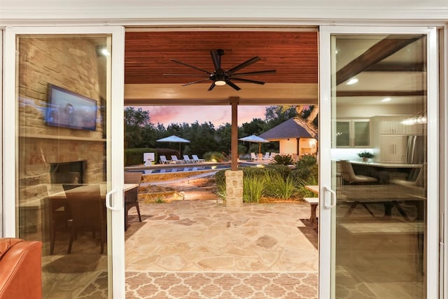 doorway to outside featuring stone finish flooring and ceiling fan