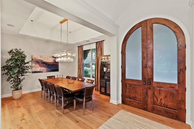 dining room featuring french doors, light wood-style flooring, baseboards, and an inviting chandelier