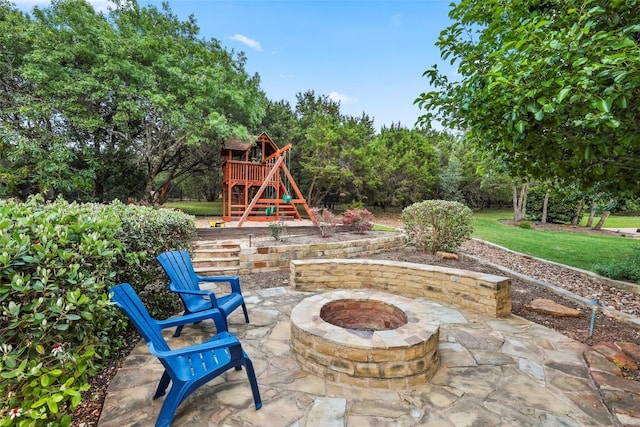 view of patio / terrace featuring a playground and an outdoor fire pit