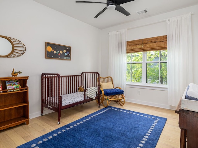 bedroom with ceiling fan, baseboards, visible vents, and wood finished floors