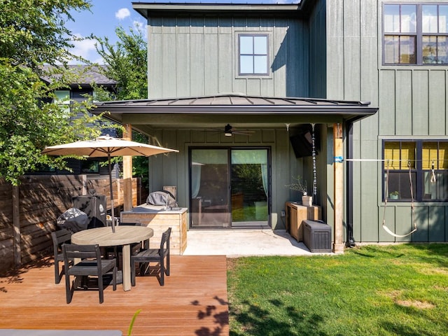 back of property featuring a standing seam roof, a ceiling fan, board and batten siding, and a yard