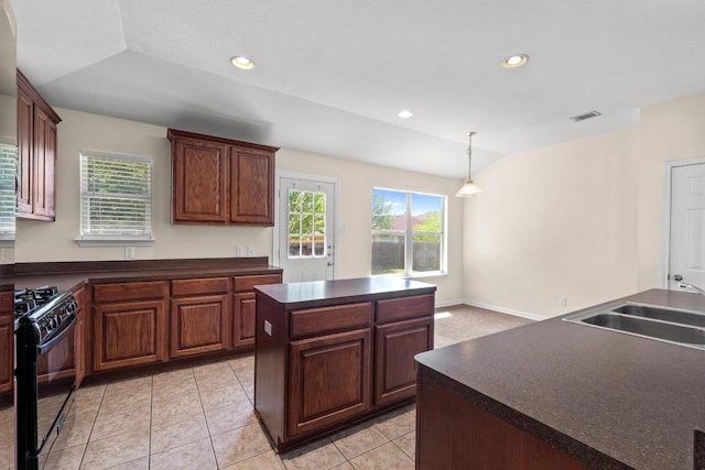 kitchen with visible vents, a kitchen island, dark countertops, black gas stove, and a sink
