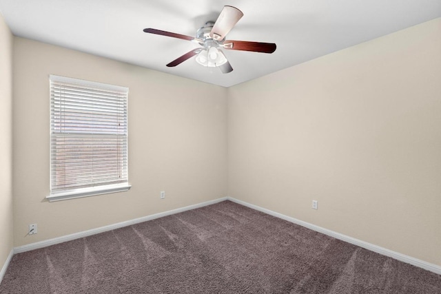 carpeted empty room featuring baseboards and a ceiling fan