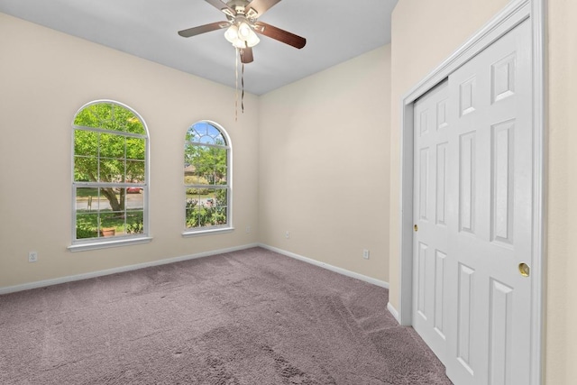 unfurnished bedroom with a closet, baseboards, ceiling fan, and carpet flooring