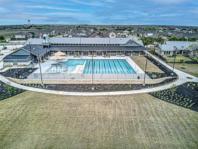 community pool with a residential view, fence, and a patio