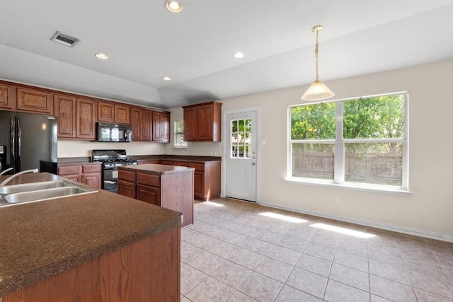 kitchen featuring visible vents, light tile patterned flooring, dark countertops, a sink, and black appliances