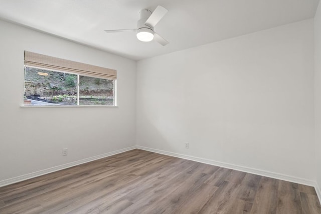 spare room featuring baseboards, a ceiling fan, and wood finished floors