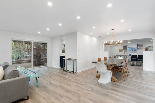 dining room with recessed lighting, baseboards, a notable chandelier, and light wood-type flooring