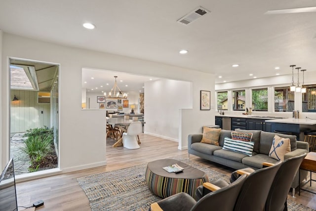 living room with visible vents, recessed lighting, light wood-style floors, and a chandelier