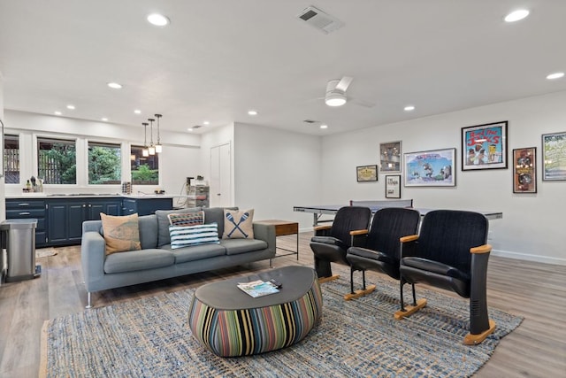 living area with visible vents, recessed lighting, light wood-style flooring, and baseboards