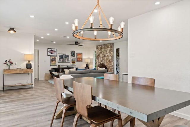 dining space with baseboards, ceiling fan with notable chandelier, recessed lighting, and wood finished floors