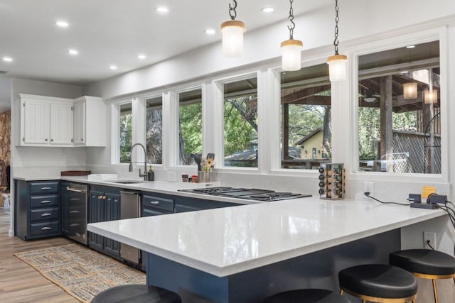 kitchen featuring white cabinets, a sink, recessed lighting, wine cooler, and blue cabinets
