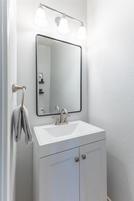 bathroom with a textured wall and vanity