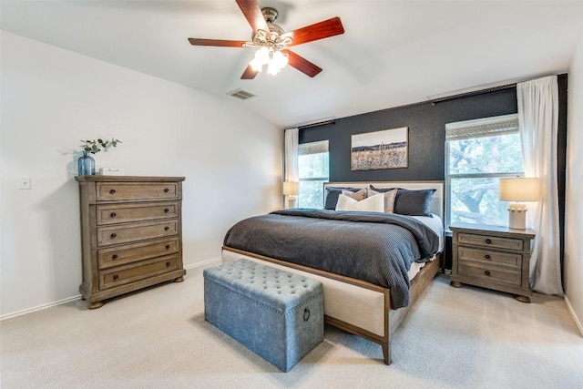 bedroom with visible vents, multiple windows, vaulted ceiling, and light carpet