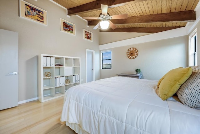 bedroom featuring baseboards, lofted ceiling with beams, wood ceiling, a ceiling fan, and light wood-style flooring