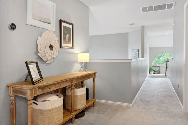 corridor featuring baseboards, an upstairs landing, carpet flooring, and visible vents