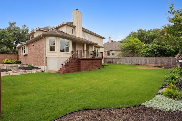 rear view of house with a yard, a chimney, a fenced backyard, and stairs