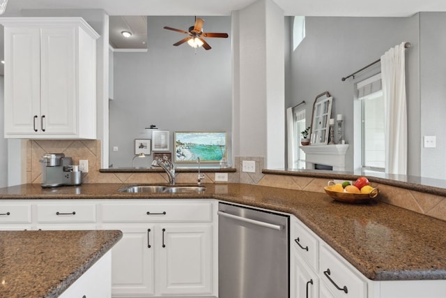 kitchen with a sink, dark stone counters, a ceiling fan, and dishwasher