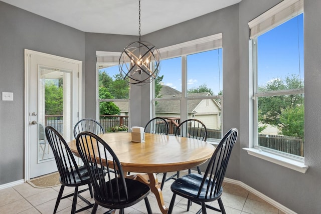 dining room with an inviting chandelier, baseboards, and light tile patterned floors