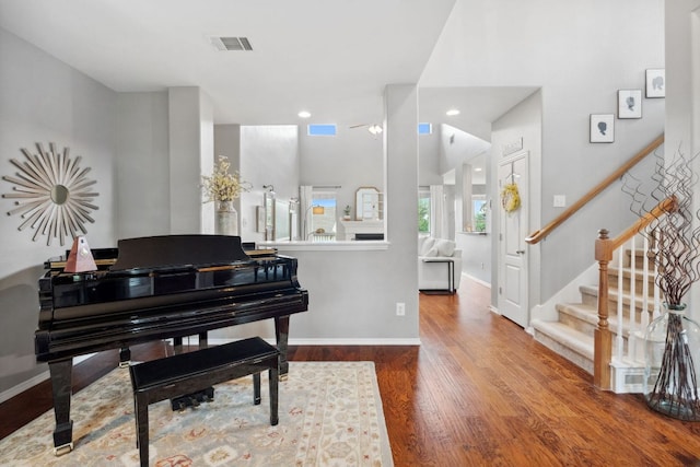sitting room with baseboards, visible vents, wood finished floors, and stairway