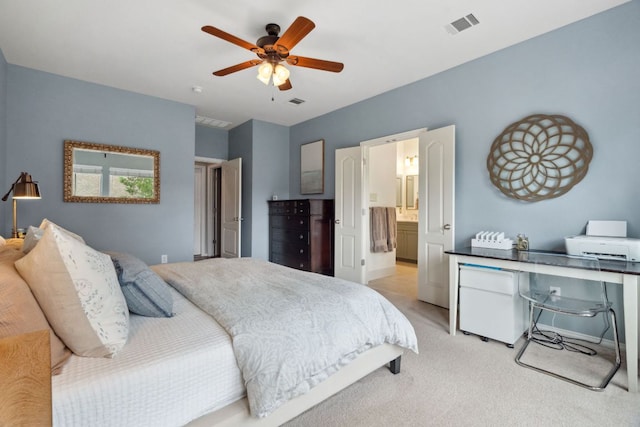 bedroom with visible vents, ceiling fan, ensuite bathroom, and light colored carpet