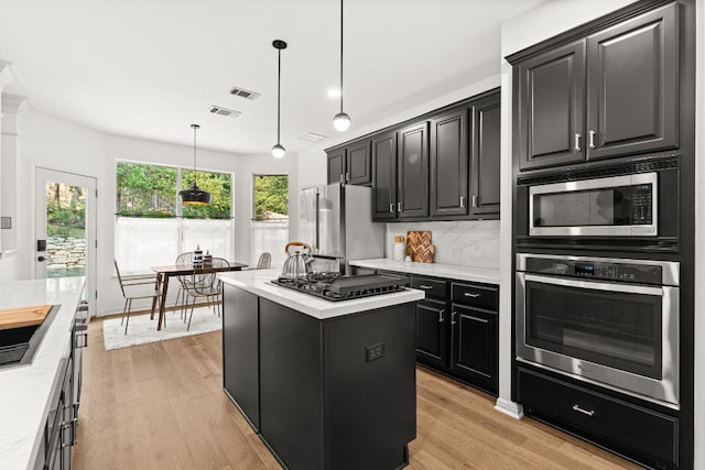 13300 Country Lake Dr, Austin, TX 78732 - kitchen with dark cabinetry, appliances with stainless steel finishes, visible vents, and light countertops