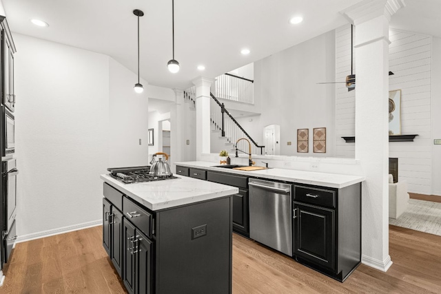 13300 Country Lake Dr, Austin, TX 78732 - kitchen with a sink, appliances with stainless steel finishes, dark cabinetry, and light wood finished floors