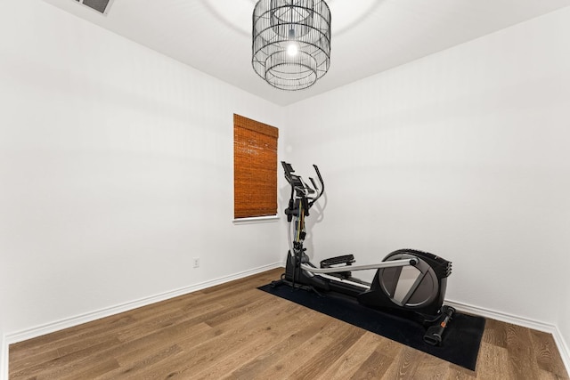13300 Country Lake Dr, Austin, TX 78732 - exercise area featuring baseboards, wood finished floors, and an inviting chandelier