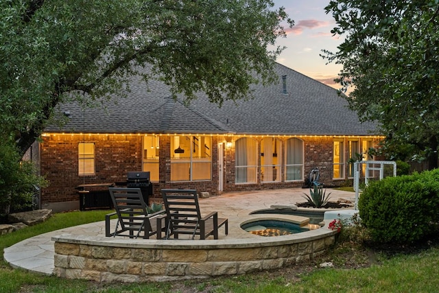 13300 Country Lake Dr, Austin, TX 78732 - rear view of property featuring brick siding, a patio area, a shingled roof, and an in-ground hot tub