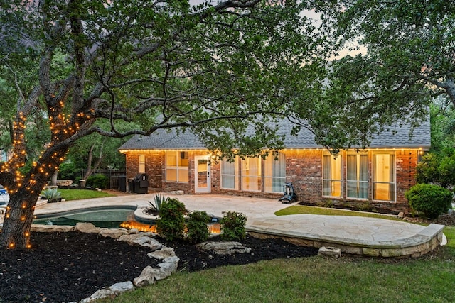 13300 Country Lake Dr, Austin, TX 78732 - back of property with a patio, brick siding, an outdoor pool, a lawn, and a shingled roof