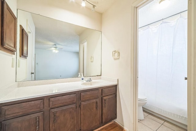 bathroom featuring vanity, curtained shower, toilet, tile patterned floors, and a ceiling fan